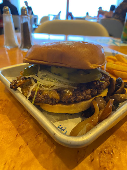 A burger (in paradise) on Margaritaville at Sea's Islander. A shaker of salt can be seen in the background.