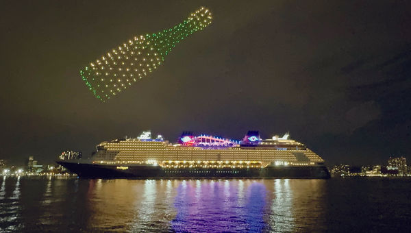 A Champagne bottle made of drones forms above the Disney Treasure.