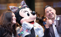 Academy Travel owner Lisa Federico celebrating her agency's 25th anniversary with Minnie Mouse and Disney regional sales director James Boniface.