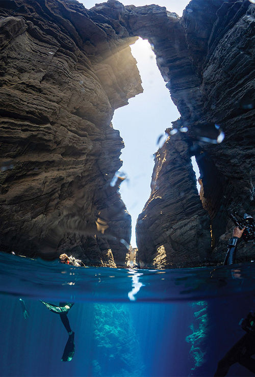 Divers in the "keyhole" rock formation on Lehua, a moon-shaped islet a half-mile off Niihau.